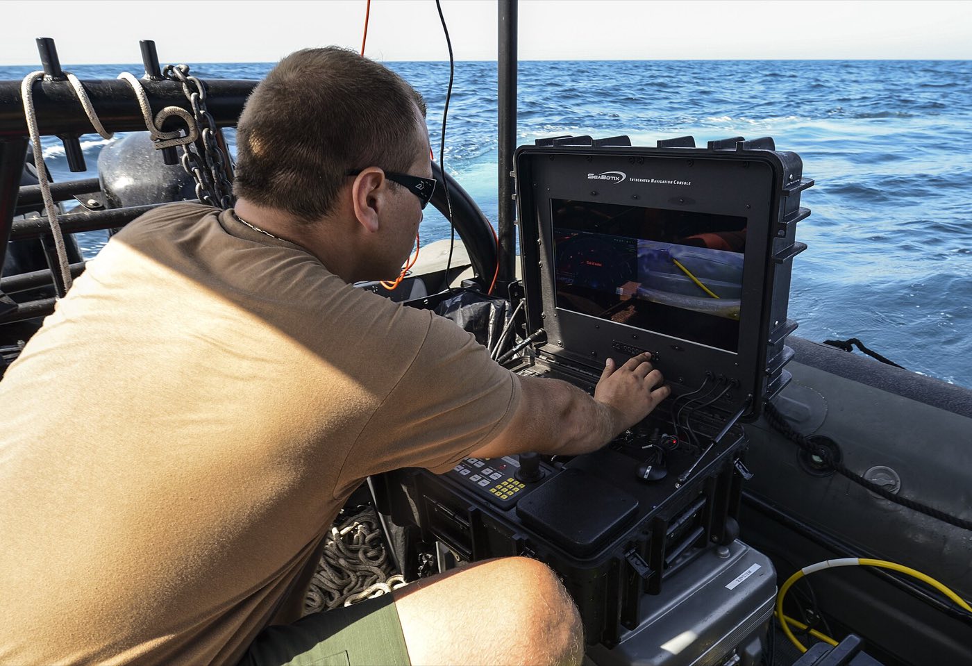 A remotely operated vehicle relays live video to an operator on the surface — the same pri